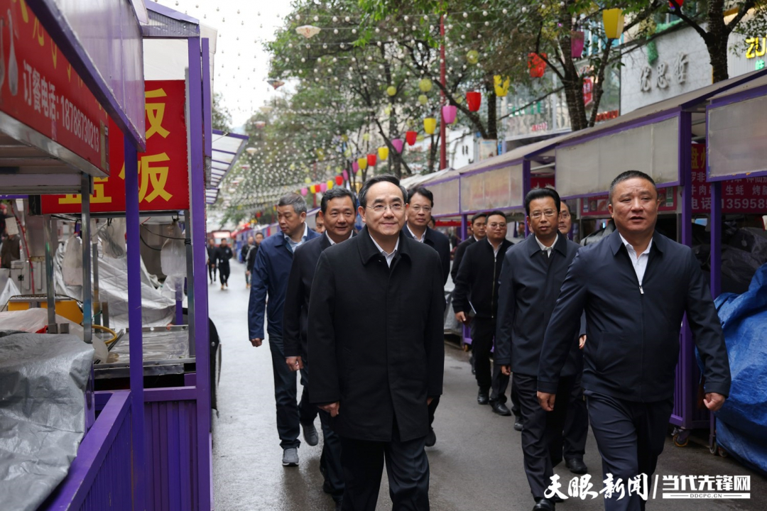 圖為徐麟在盤州市亦資街道三峽北路小吃一條街，察看店面攤點管理情況。.jpg